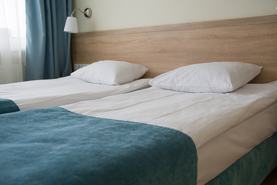Accommodation lounge with two beds against a wooden headboard