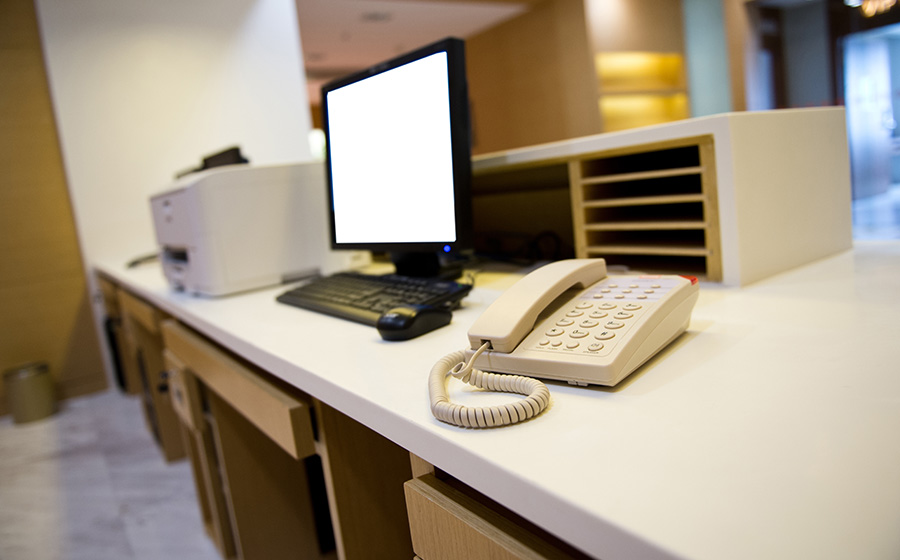 Computer monitor, phone and printer on front desk of medical office